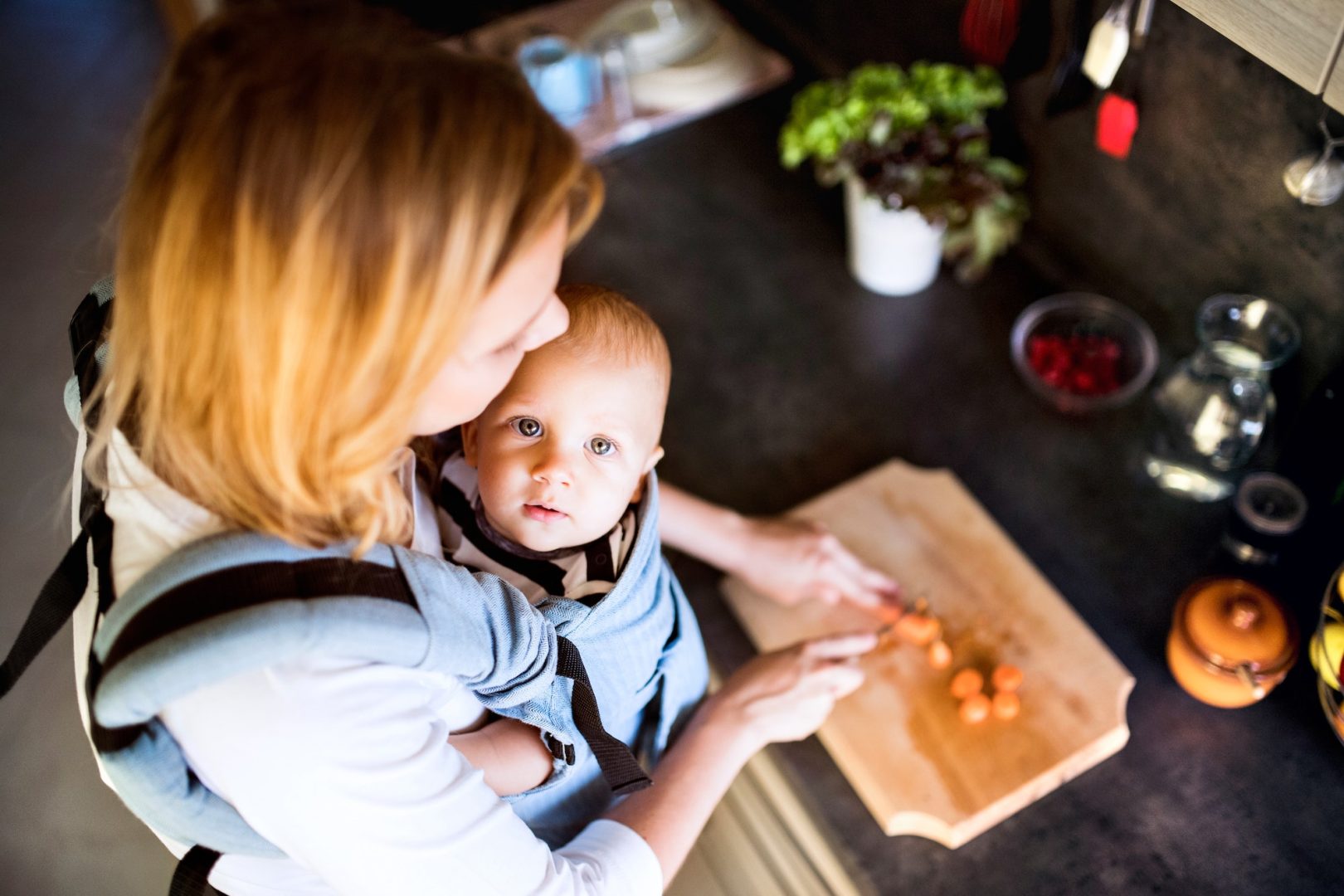 Young mother with a baby boy doing housework.